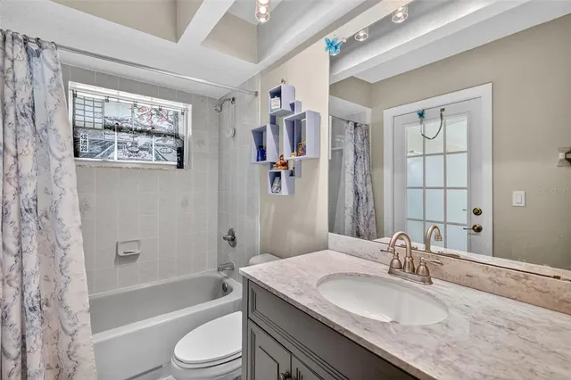 a bathroom with a granite countertop sink toilet tub and shower