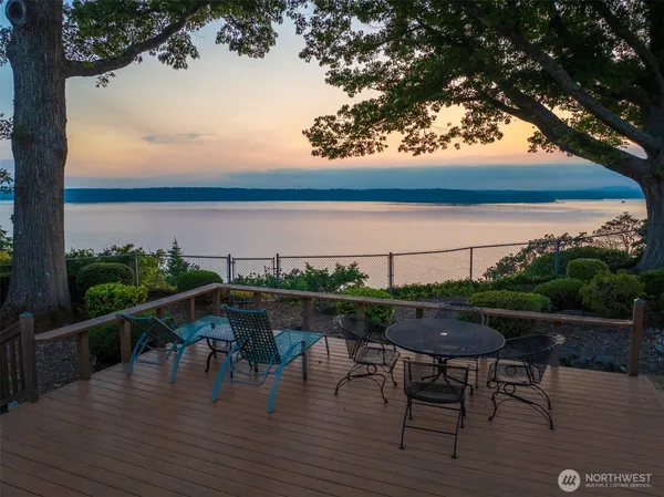 a terrace with wooden floor table and chairs