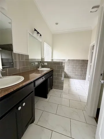 a spacious bathroom with a granite countertop sink a mirror and a bathtub