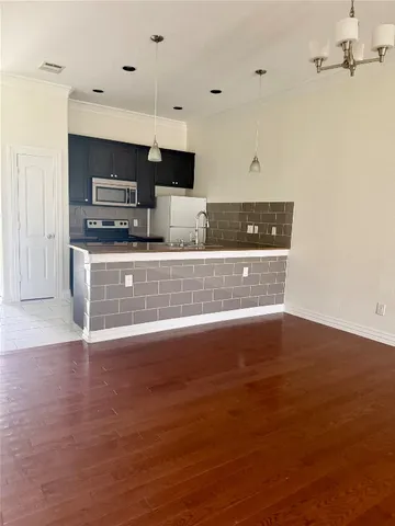 a view of kitchen with stainless steel appliances granite countertop a sink and stove top oven