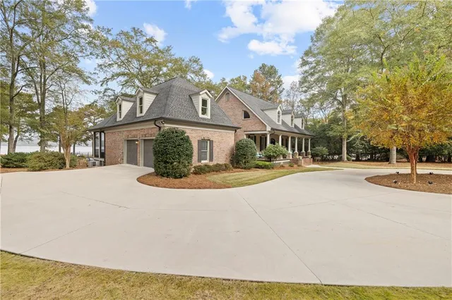 a view of house with yard and trees in the background