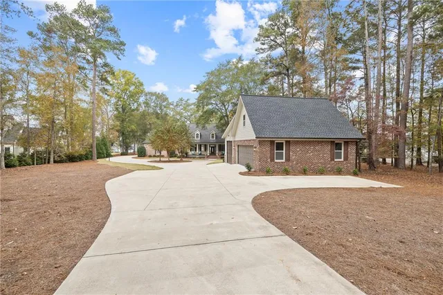 a view of a house with a yard and large trees