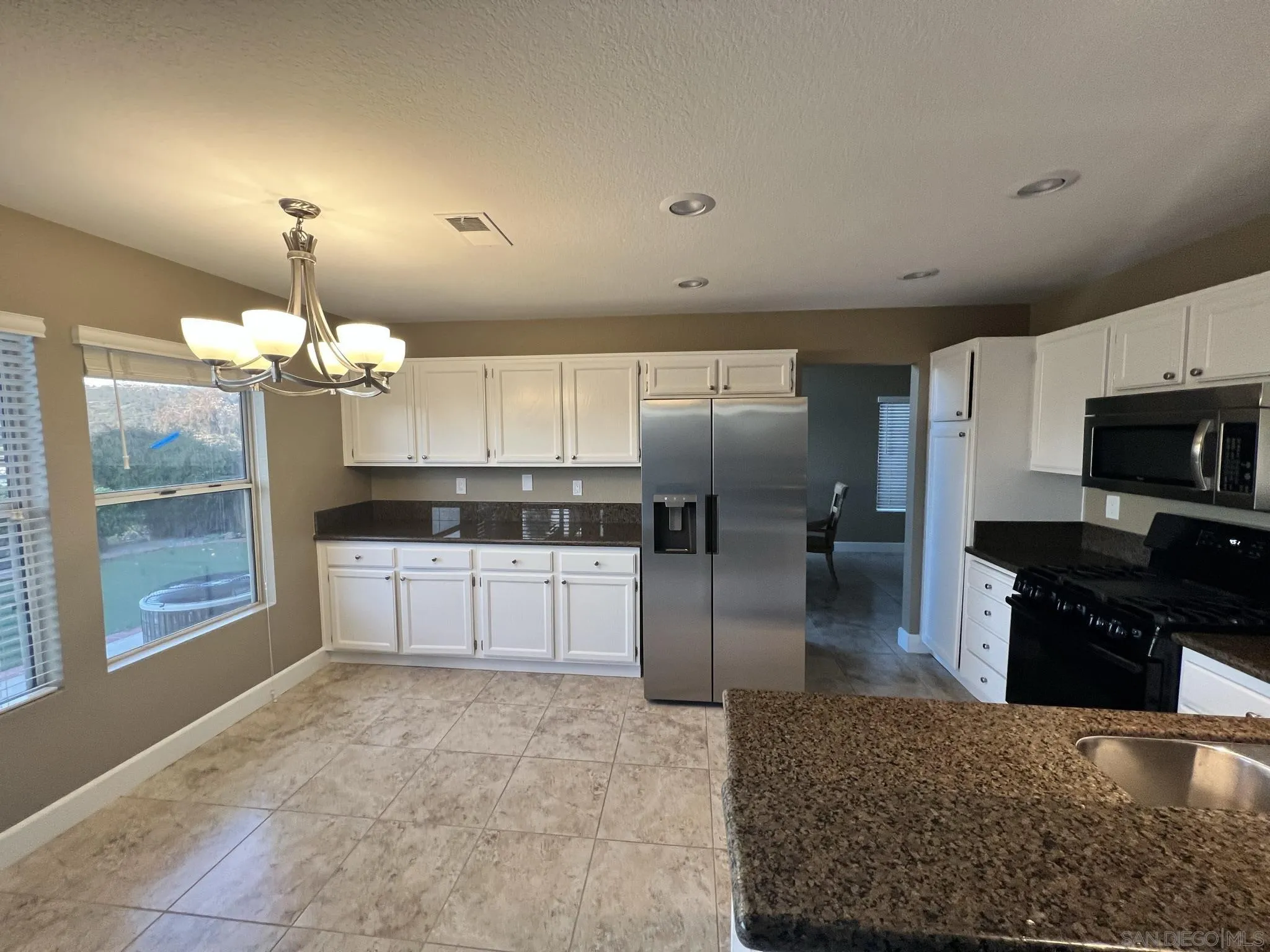 1565 Bay Meadows Drive Alpine, CA 91901 - Photo 6 of 23 a kitchen with granite countertop a refrigerator and a stove