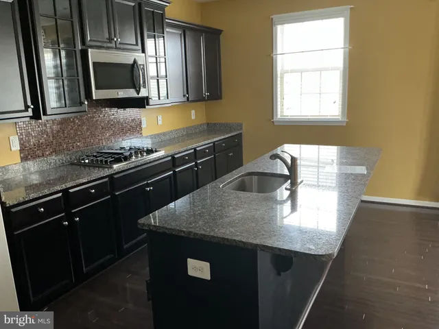 a kitchen with granite countertop a stove and a sink