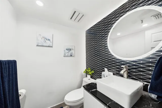 a bathroom with a sink toilet and mirror