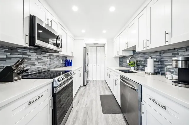 a kitchen with stainless steel appliances granite countertop a stove sink microwave and cabinets