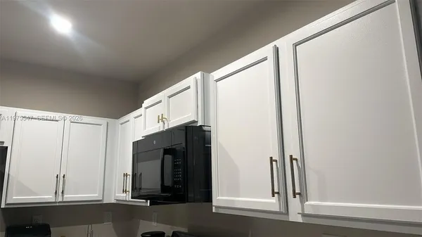 an entryway with wooden floor and cabinet