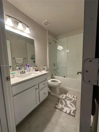 a bathroom with a bathtub shower sink mirror and toilet