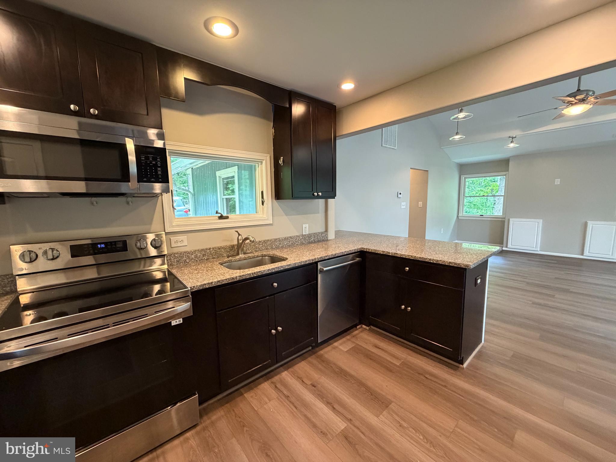 146 Trillium Trail Road Linden, VA 22642 - Photo 5 of 21 a kitchen with stainless steel appliances kitchen island granite countertop a stove a sink and a microwave