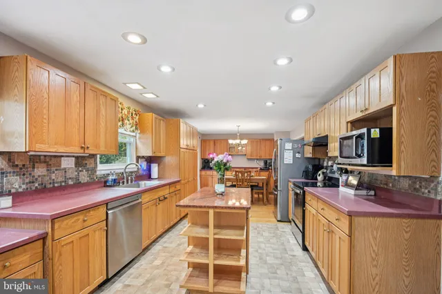 a kitchen with lots of counter top space a sink appliances and cabinets