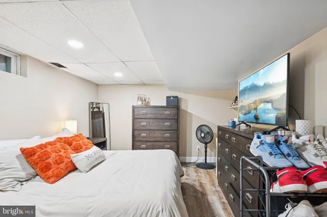 a bedroom with a bed dresser and flat screen tv