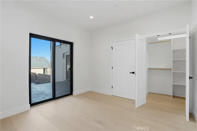 a view of a white house with a small yard and wooden fence and a potted plant