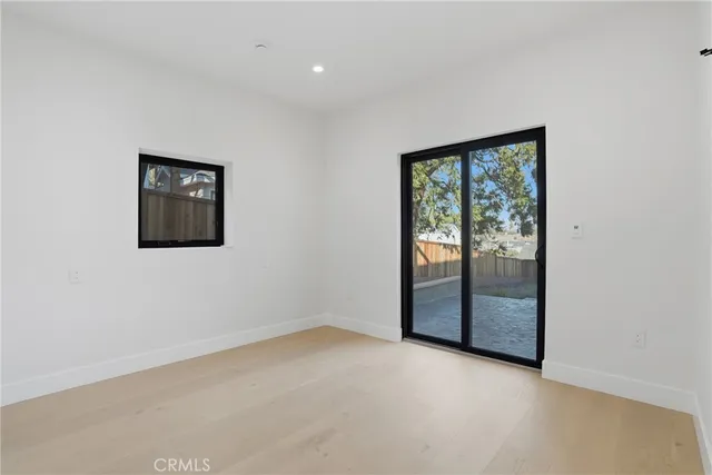 a view of a white house next to a yard with wooden fence