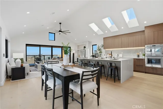 a kitchen with stainless steel appliances a table and chairs in it