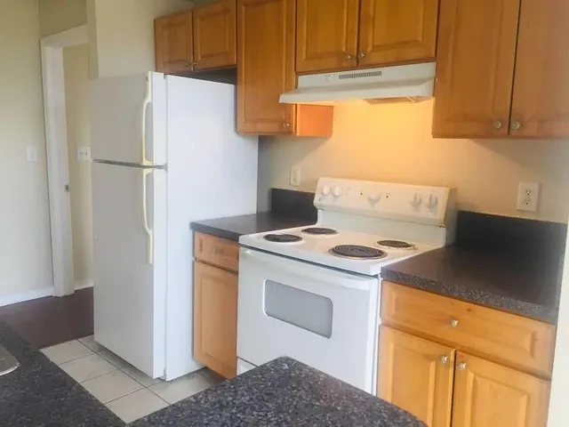 a kitchen with a refrigerator sink and cabinets