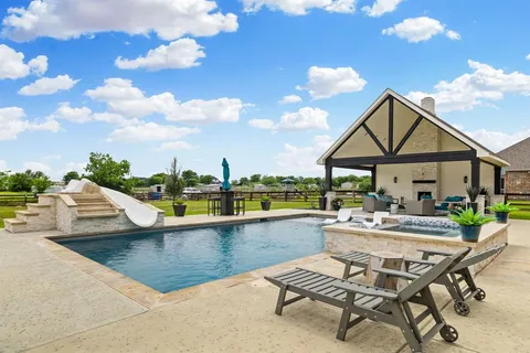 a front view of a house with swimming pool having outdoor seating