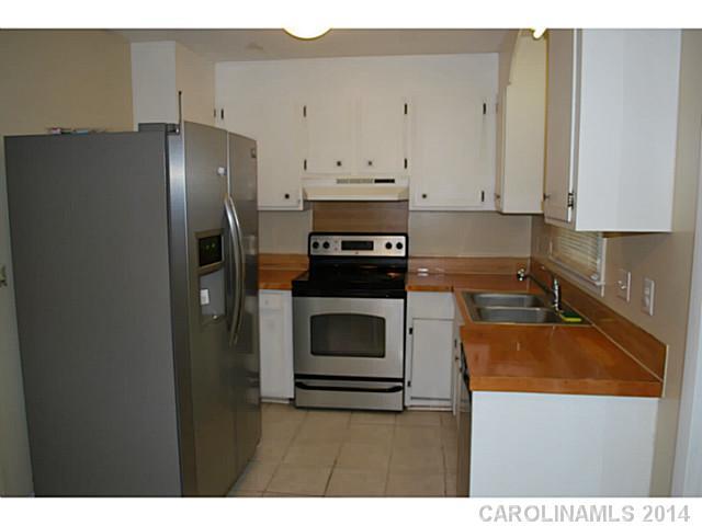 6137 Trotters Ridge Road Charlotte, NC 28227 - Photo 5 of 11 a kitchen with refrigerator cabinets and stove
