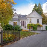 a front view of a house with a yard and potted plants