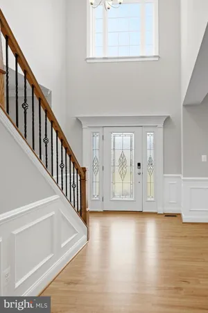 an empty room with wooden floor fireplace and windows