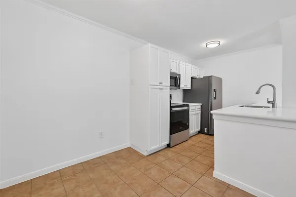 a kitchen with a refrigerator and a stove top oven