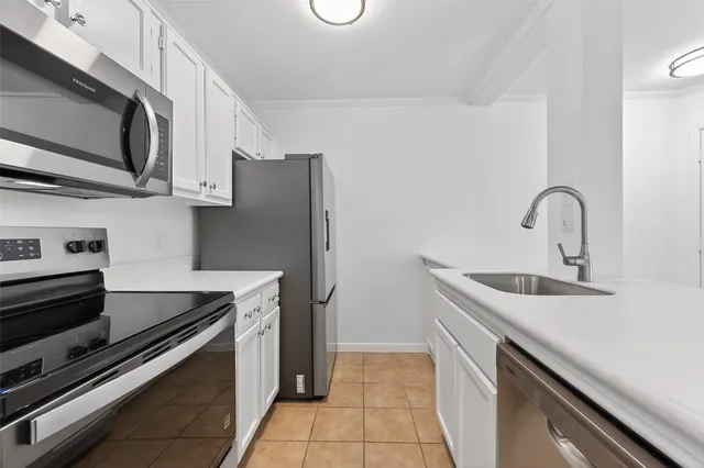 a kitchen with stainless steel appliances a sink stove and microwave