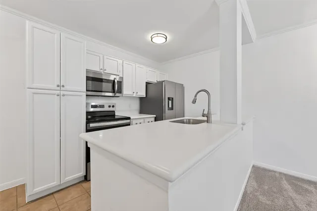 a kitchen with kitchen island a sink appliances and cabinets