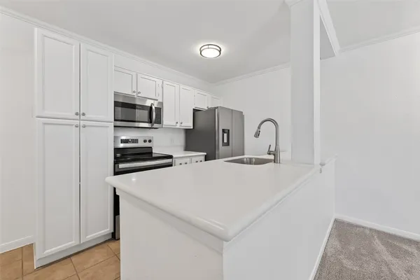 a kitchen with stainless steel appliances a refrigerator sink and microwave