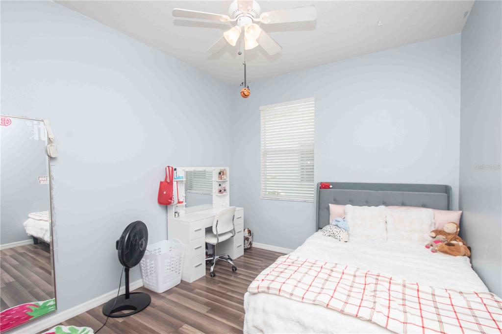269 Fairmont Drive Spring Hill, FL 34609 - Photo 12 of 32 a bedroom with a bed and a chandelier
