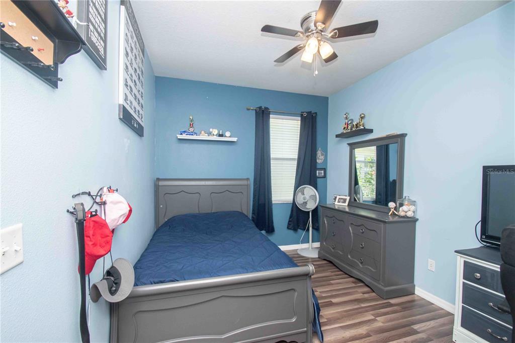 269 Fairmont Drive Spring Hill, FL 34609 - Photo 14 of 32 a bedroom with a bed and wooden floor