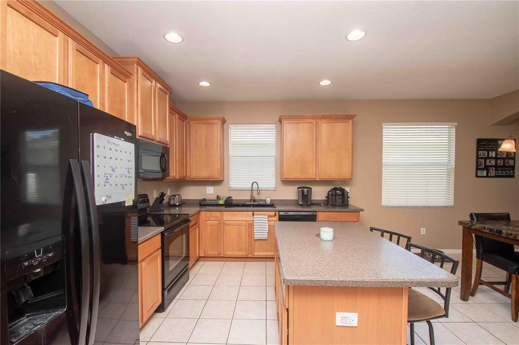 269 Fairmont Drive Spring Hill, FL 34609 - Photo 2 of 32 a kitchen with stainless steel appliances granite countertop a stove refrigerator sink microwave and cabinets