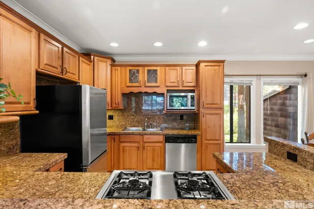 a kitchen with stainless steel appliances granite countertop a stove a refrigerator and a sink