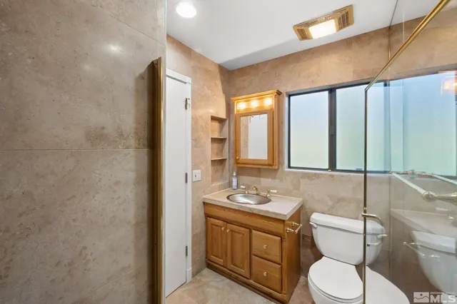 a bathroom with a granite countertop sink toilet and shower