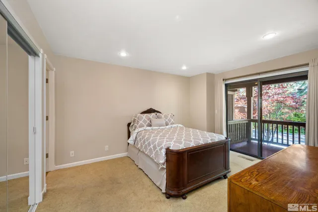 a bed sitting in a spacious bedroom next to a window