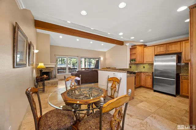 a kitchen with a refrigerator a dining table and chairs