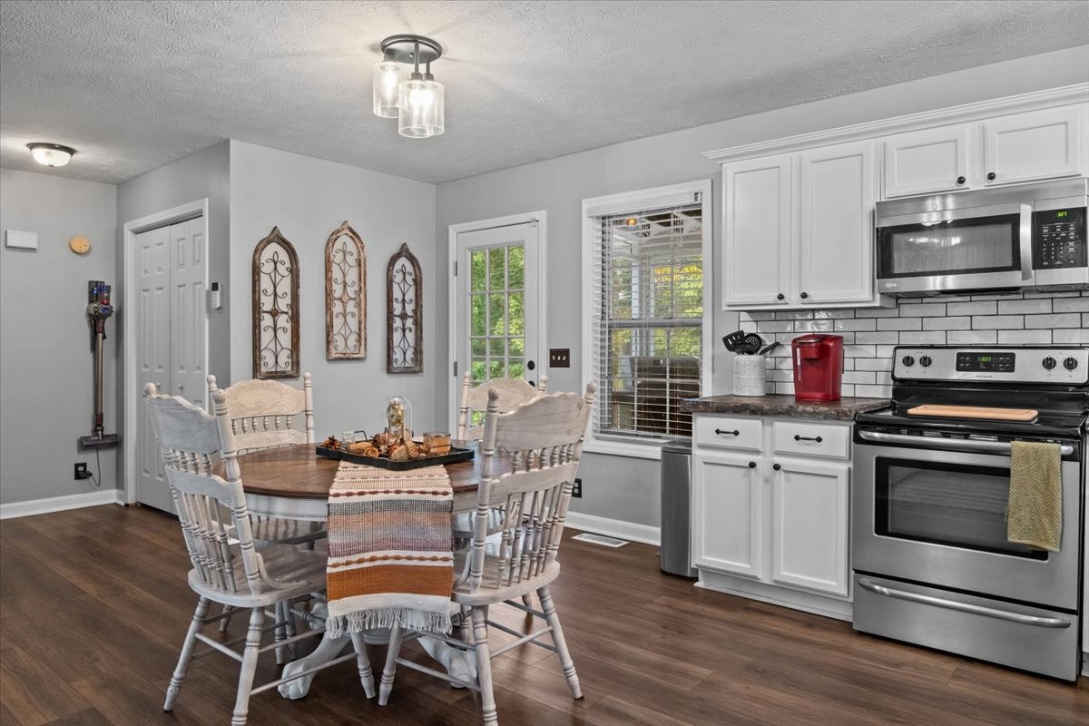 5790 Washer Road Lyles, TN 37098 - Photo 18 of 31 a kitchen with stainless steel appliances granite countertop a stove a sink dishwasher a dining table and chairs with wooden floor