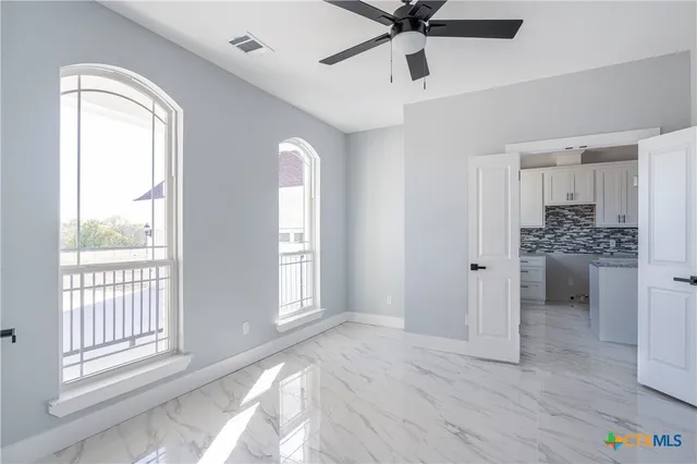 a view of a livingroom with a ceiling fan and window