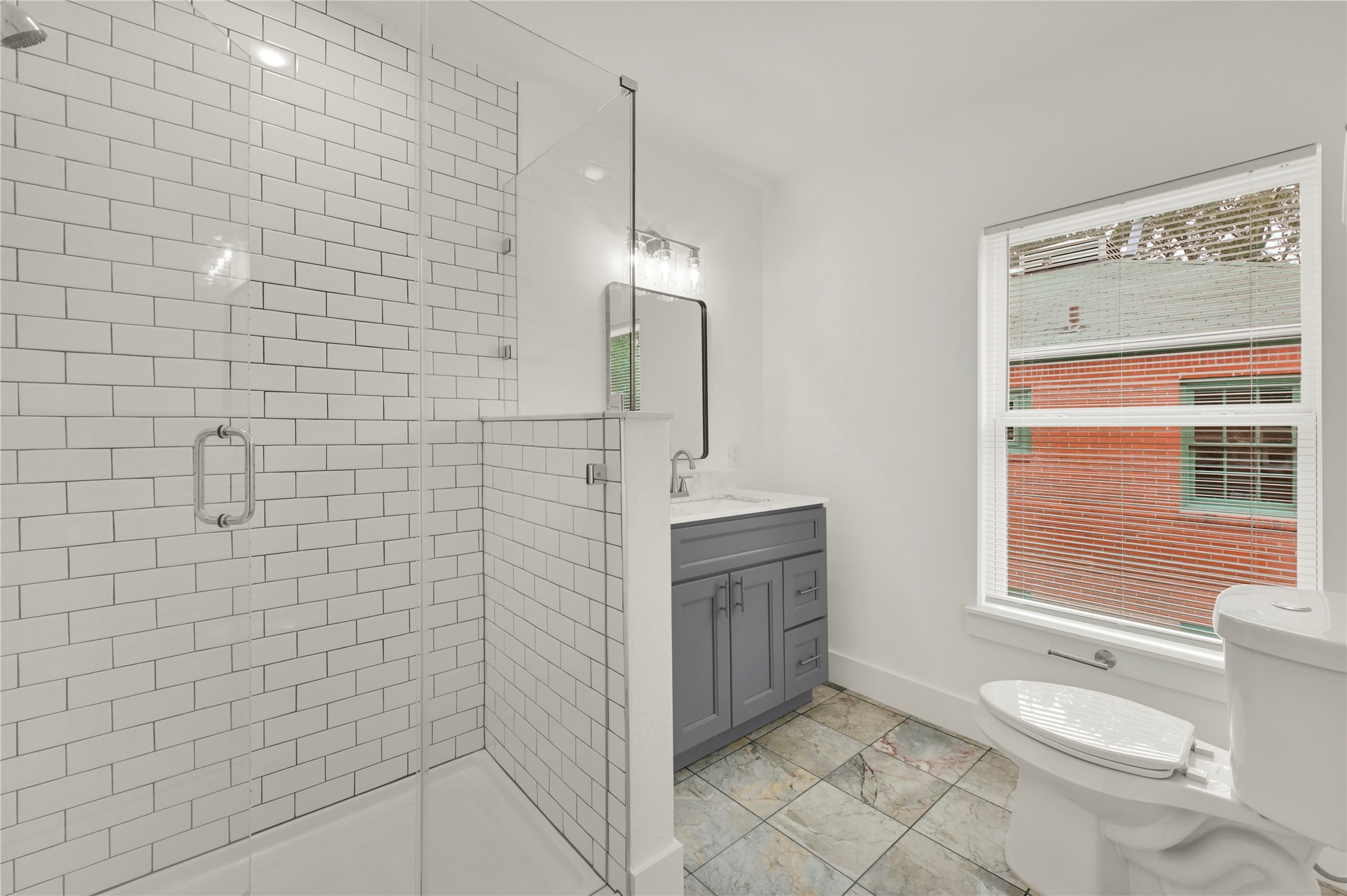 6620 Lawndale Street, Unit 4 Houston, TX 77023 - Photo 4 of 6 a bathroom with a granite countertop sink a toilet and shower