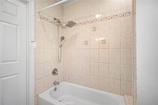a bathroom with a tub shower and a sink