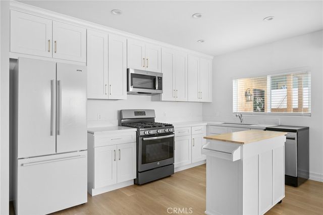 a kitchen with white cabinets and stainless steel appliances