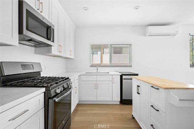 a kitchen with stainless steel appliances a stove microwave and cabinets