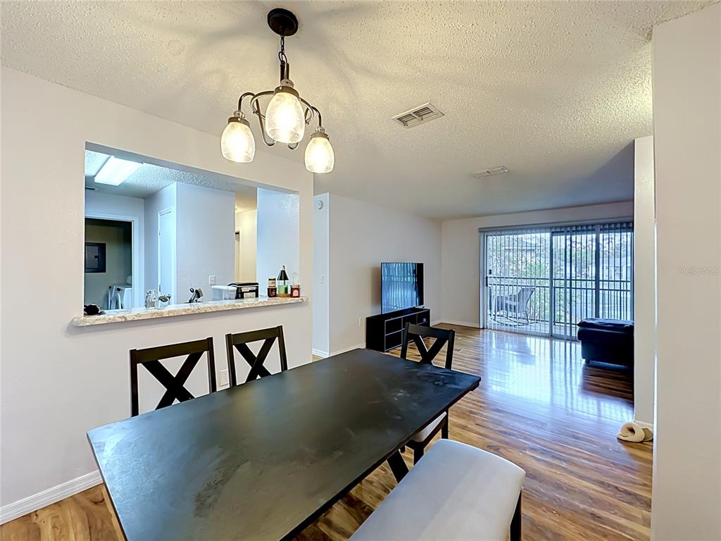 3705 Southwest 27th Street, Unit 922 Gainesville, FL 32608 - Photo 4 of 34 a view of a dining room with furniture window and wooden floor