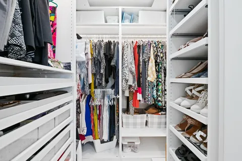 a view of walk in closet with clothes and shoes