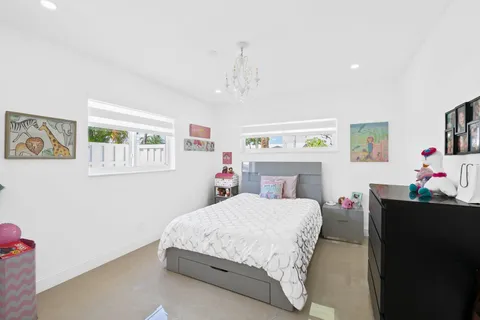 a bedroom with a bed dresser and window