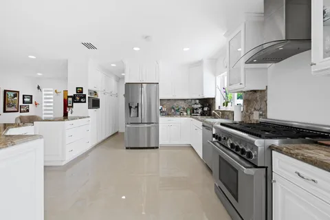 a kitchen with stainless steel appliances a refrigerator sink and cabinets