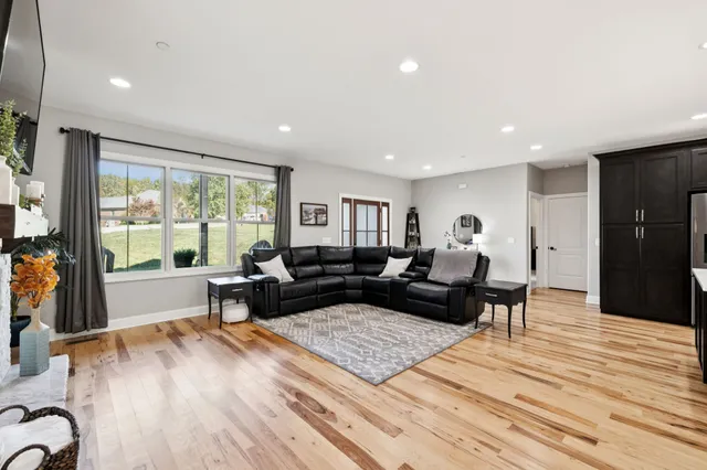 a kitchen with stainless steel appliances granite countertop a refrigerator a sink dishwasher and a stove with wooden floor