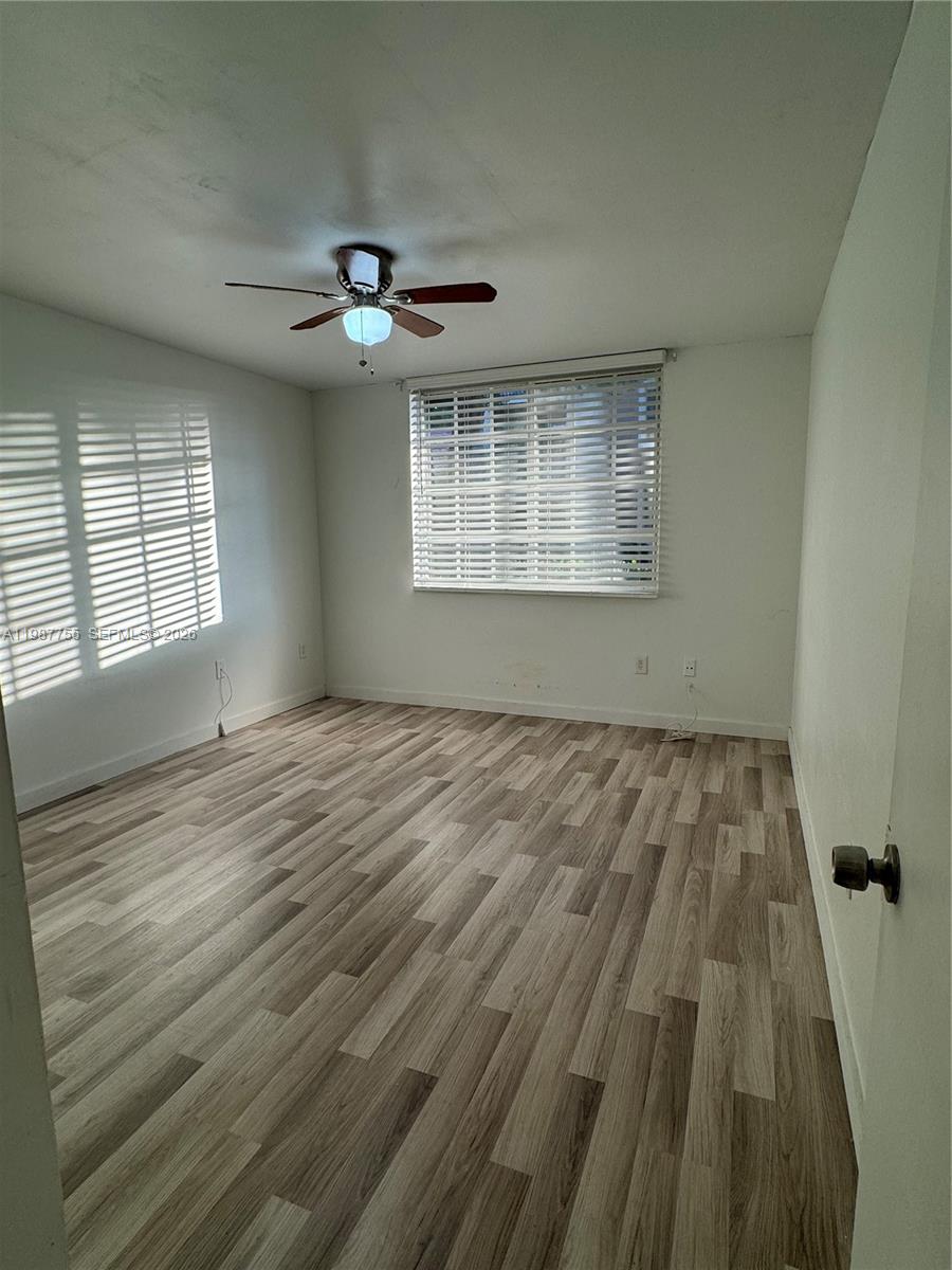2071 Renaissance Boulevard, Unit 104 Miramar, FL 33025 - Photo 14 of 17 wooden floor in an empty room with a window