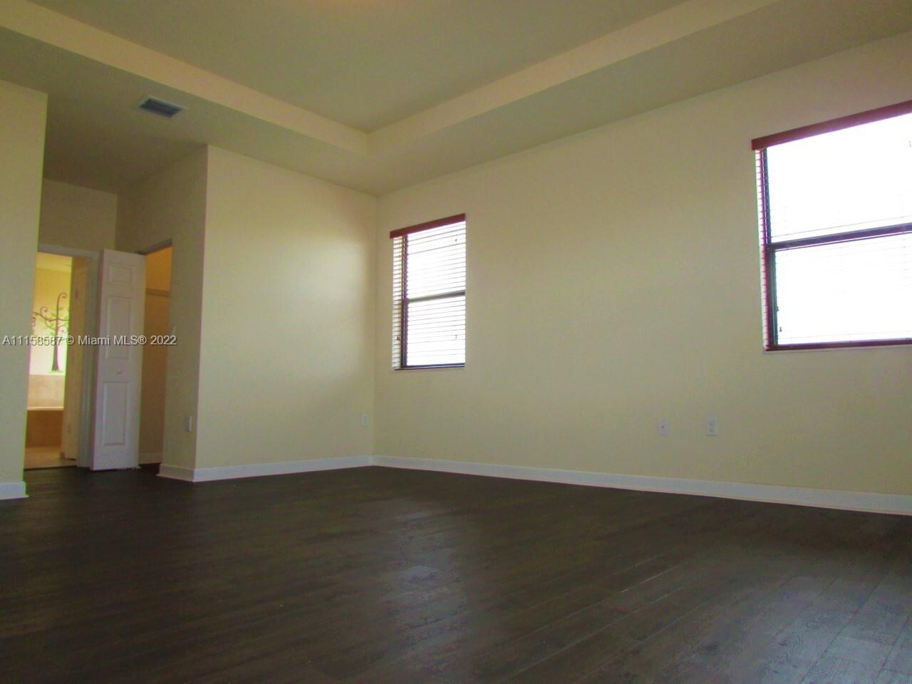 11759 Southwest 235th Street Homestead, FL 33032 - Photo 11 of 21 an empty room with wooden floor and windows
