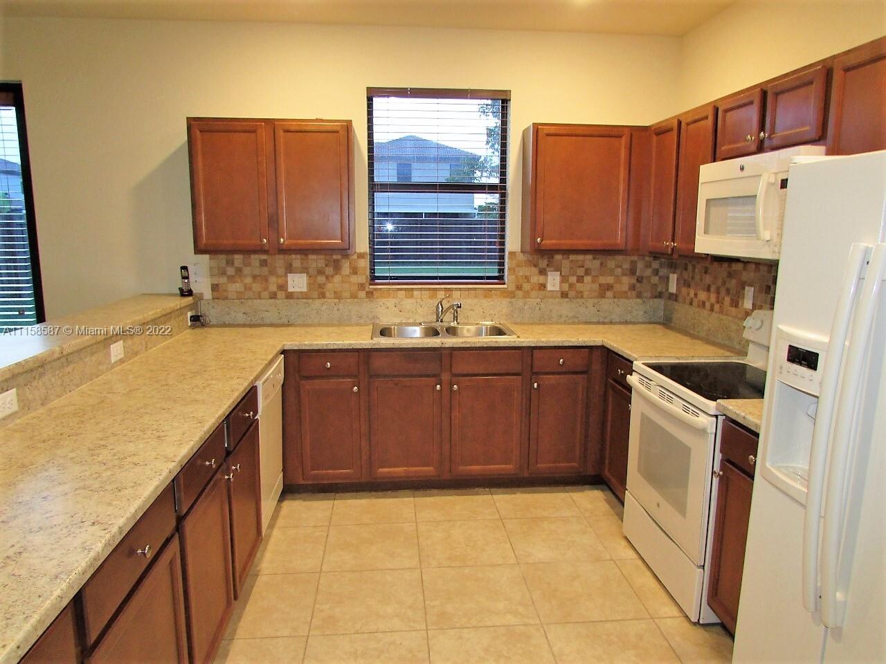 11759 Southwest 235th Street Homestead, FL 33032 - Photo 18 of 21 a kitchen with a sink stove and cabinets