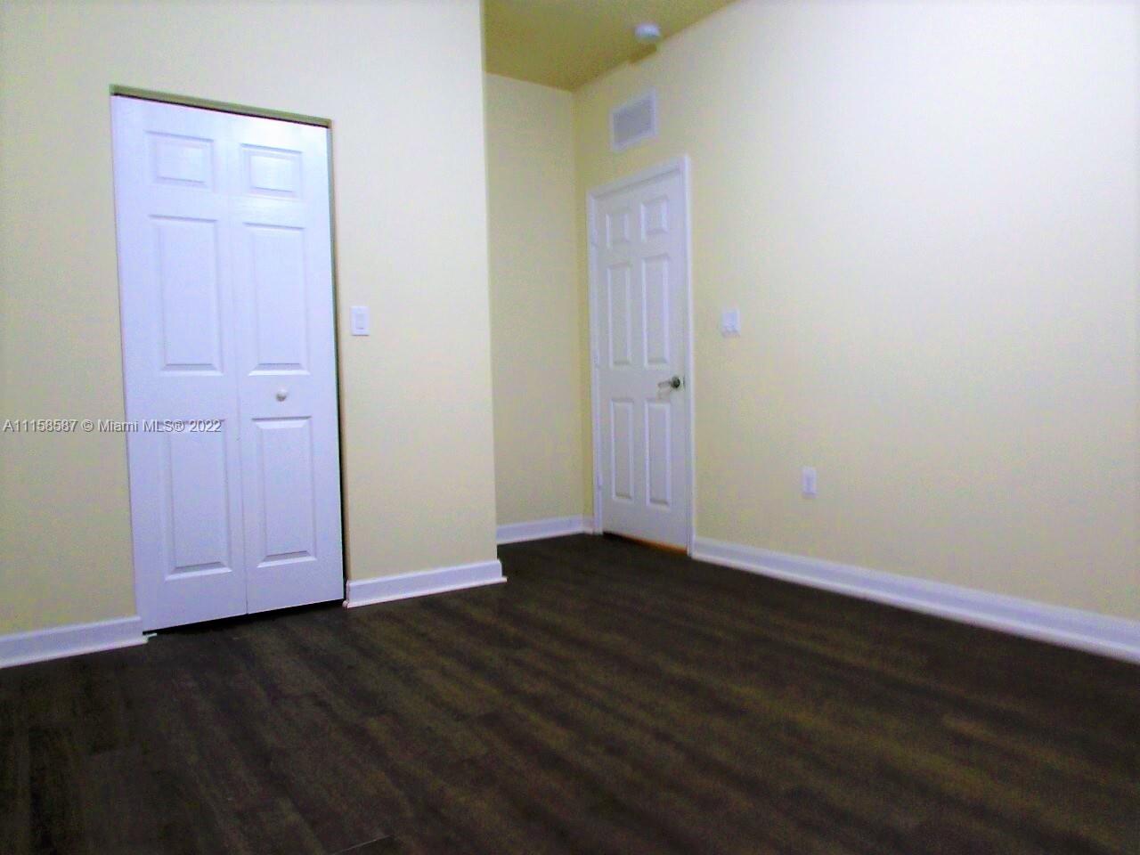 11759 Southwest 235th Street Homestead, FL 33032 - Photo 19 of 21 an empty room with wooden floor and closet area