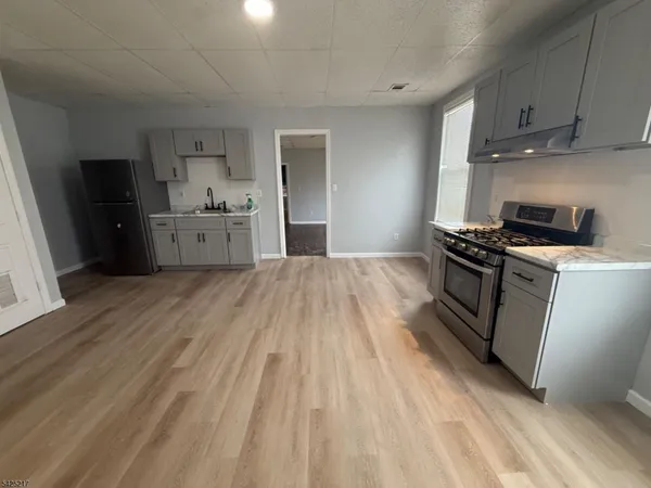 a kitchen with granite countertop a sink cabinets and stainless steel appliances